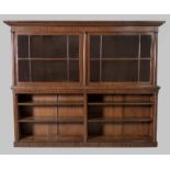 A VICTORIAN MAHOGANY BOOKCASE, the upper section with a swept moulded pediment above twin multi-
