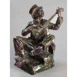 LLEWELLYN OWEN DAVIES (SOUTH AFRICAN: 1950 - ), SEATED MINSTREL PLAYING A BANJO, bronze sculpture,