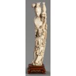 A SUPERB IVORY CARVING OF A LADY HOLDING A FLOWER BASKET, SECOND HALF OF THE 19th CENTURY, her