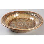 HYME RABINOWITZ (SOUTH AFRICAN: 1920 - 2009), a brown glazed dish with revereted rim, decorated with