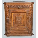 A 19TH CENTURY GERMAN OAK STANDING CORNER CABINET, the moulded top above a single carved drawer