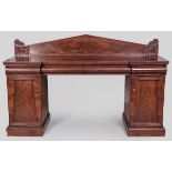 A REGENCY MAHOGANY SIDEBOARD, the broken front with a pyramid back-rail above one long and two short