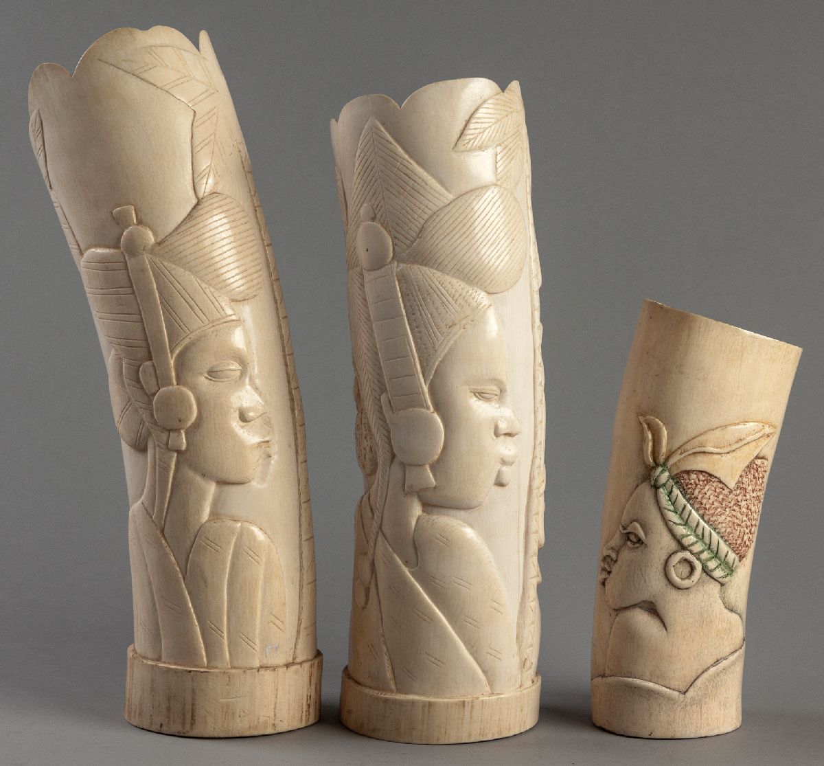 A PAIR OF CARVED AFRICAN IVORY TUSKS, depicting the profiles of African women and elephants,