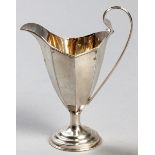 AN EDWARDIAN SILVER CREAMER, BIRMINGHAM 1904, W & A, C-scroll reeded handle, segmented body on a