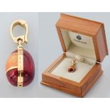 A CARL FABERGE 18CT GOLD AND RED ENAMEL EGG CHARM, the centre band stamped with "750, Faberge, 81/