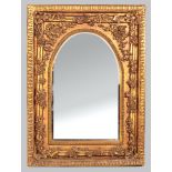 A RECTANGULAR MIRROR FRAME, housing a bevelled arched mirror, set into a beaded slip with neo-
