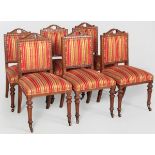 A SET OF SIX EDWARDIAN CARVED OAK DINING CHAIRS, the pierced top-rails above husk decoration,