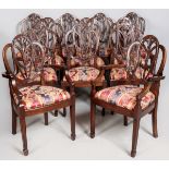 A SET OF TWELVE GEORGE III-STYLE MAHOGANY DINING CHAIR, with two carvers, the shield backs depicting