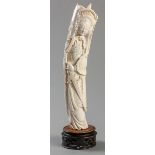 A 20TH CENTURY CHINESE IVORY CARVING OF A GODDESS, holding a sword and a spear with an elaborate