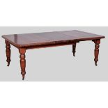 AN EDWARDIAN MAHOGANY EXTENDING DINING TABLE, the moulded top with canted corners including two