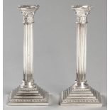 A PAIR OF SILVERPLATE CORINTHIAN COLUMN CANDLESTICKS, BY GODDINGER, beaded, rimmed wax pans, of