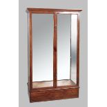 AN EARLY 20TH CENTURY MAHOGANY DISPLAY CABINET, with a stepped swept pediment, glass doors and sides