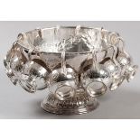 A SILVERPLATE PUNCH BOWL WITH TWELVE CUPS, fold-over rim, the bowl emobssed with flowers and leaves,