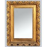 A RECTANGULAR GILT FRAMED MIRROR, the plate with multi-slips in a carved and pierced foliate