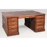 A MASSIVE 20TH CENTURY OAK PARTNER'S DESK, probably American, the highly figured moulded top above