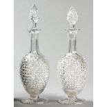 A PAIR OF CUTGLASS DECANTERS, the removable stoppers with diamond patterns, the neck with beaded