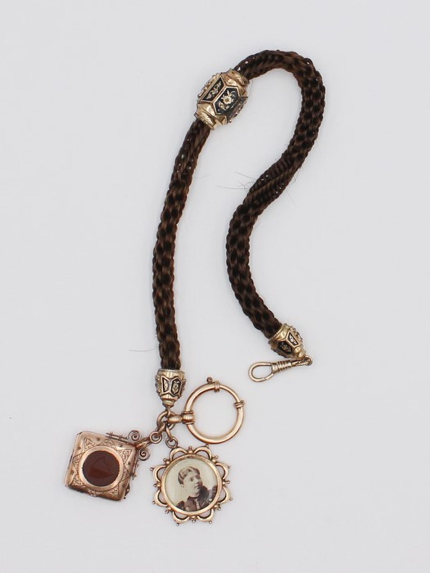 UhrenketteBiedermeier, aus geflochenen Haaren, mit diversen Abhängungen aus Schaumgold, 1x besetzt