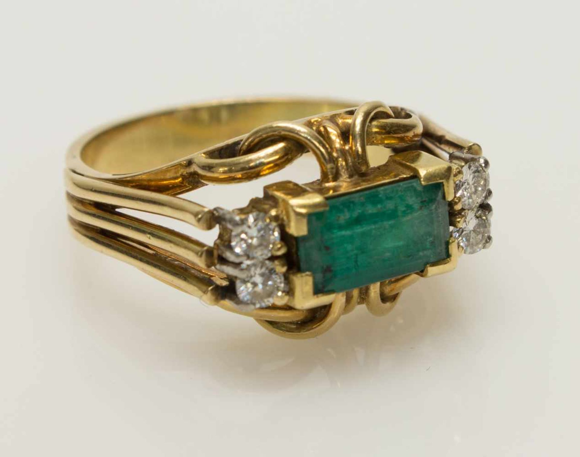 Damenring585er GG, 6,6 g, erhabener durchbrochener Ringkopf, mit einem Smaragd im Baguetteschliff,