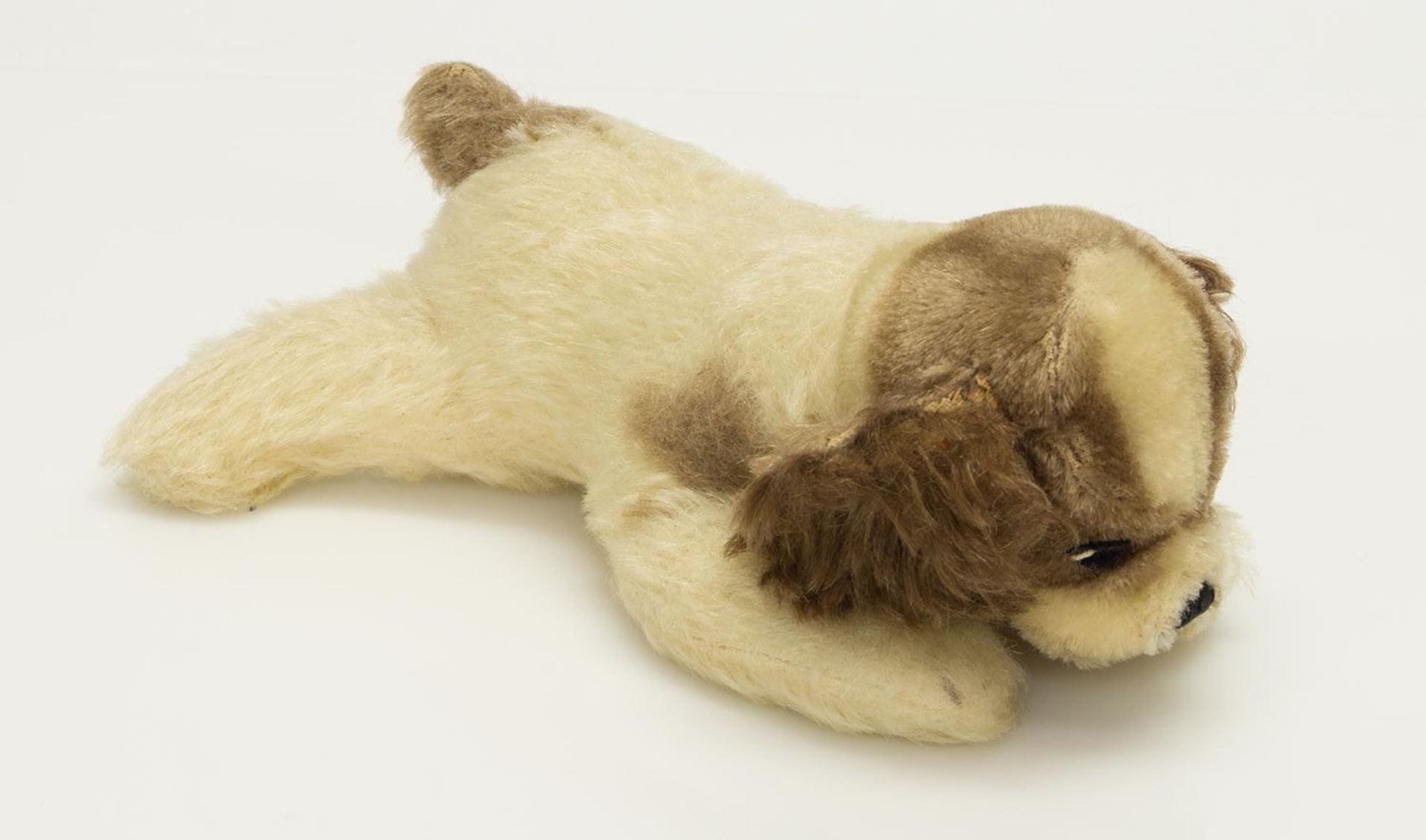 Steiff HundLiegender Steiffhund mit Knopf u. Fahne, um 1960er Jahre, L. 20,5 cm