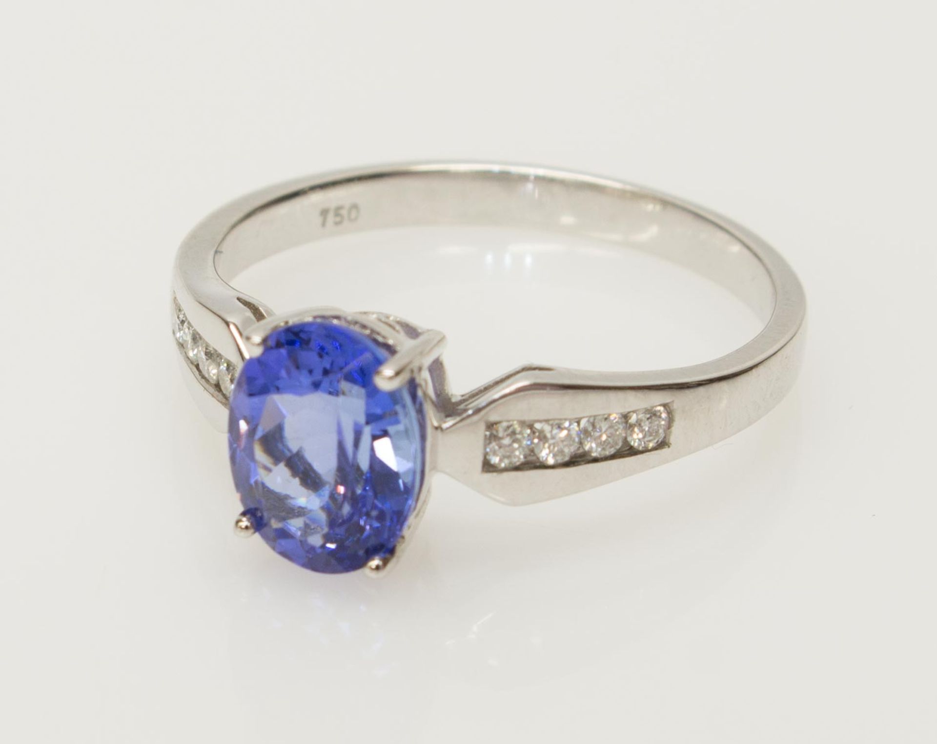Damenring750er WG, 3,8 g, Ringschiene im Verlauf, ovaler Ringkopf mit einem blauen Tansanit (ca. 1,
