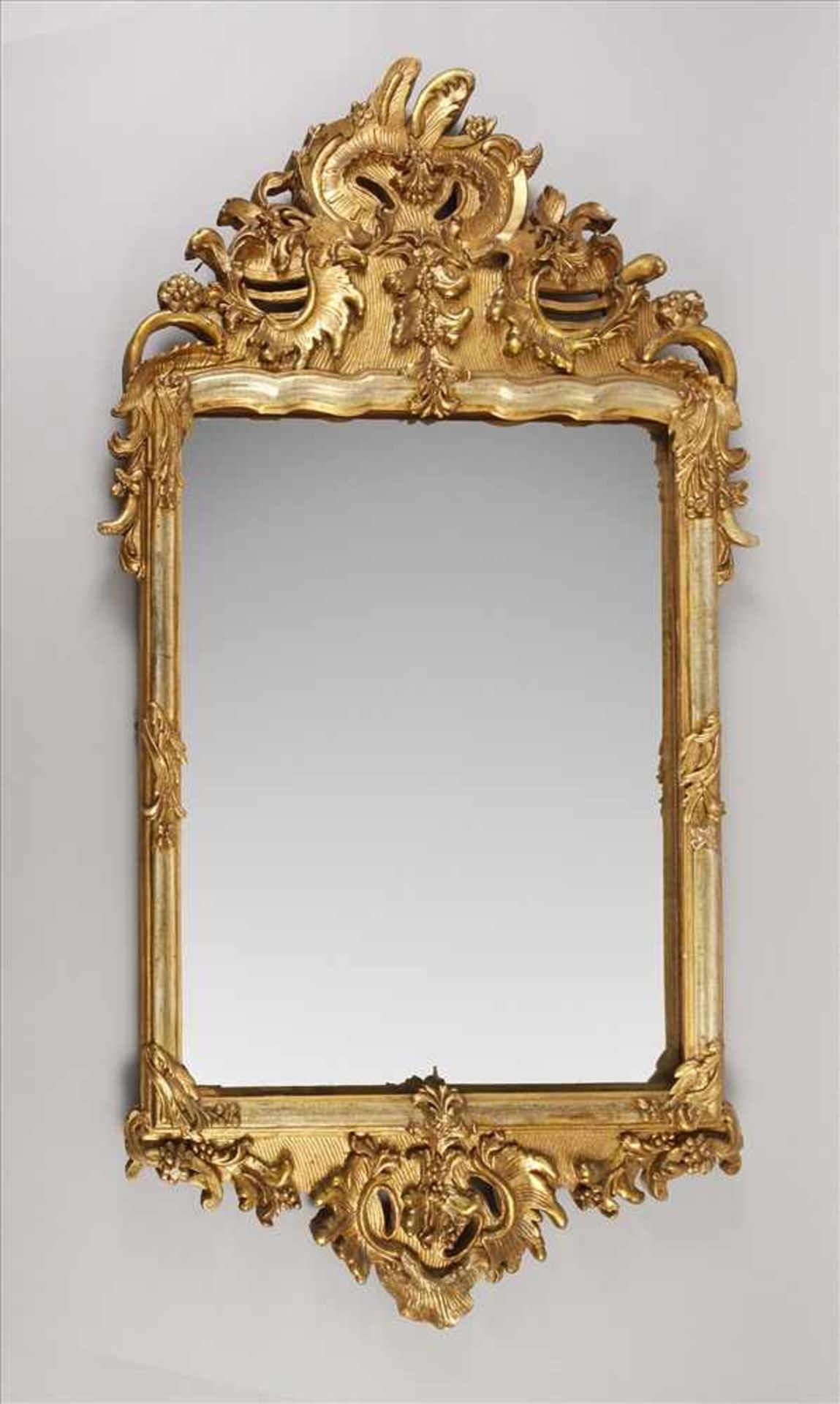 Feiner BarockspiegelMitte 18. Jh., Holz geschnitzt, gestuckt und vergoldet, mit Rocaillen und