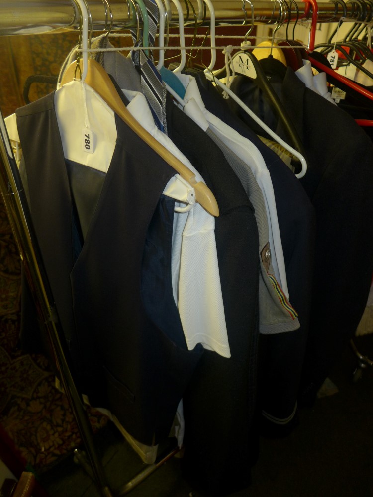 A part rail of gents' clothing including two United Airlines uniform jackets, other jackets, shirts,