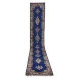 KIRMAN RUNNER, FIRST HALF OF THE 20TH CENTURY with floral medallions on blue ground. Measures cm.