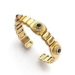 BANGLE in yellow gold 18 kts., decorated with emerald, sapphire and cabochon ruby, surrounded by