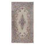 SMALL KIRMAN CARPET, MID-20TH CENTURY with floral medallion in the center field on beige ground.