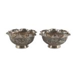 TWO SMALL SILVER BOWLS, CHINA 20TH CENTURY chiseled with devotional motifs and animals in landscape.