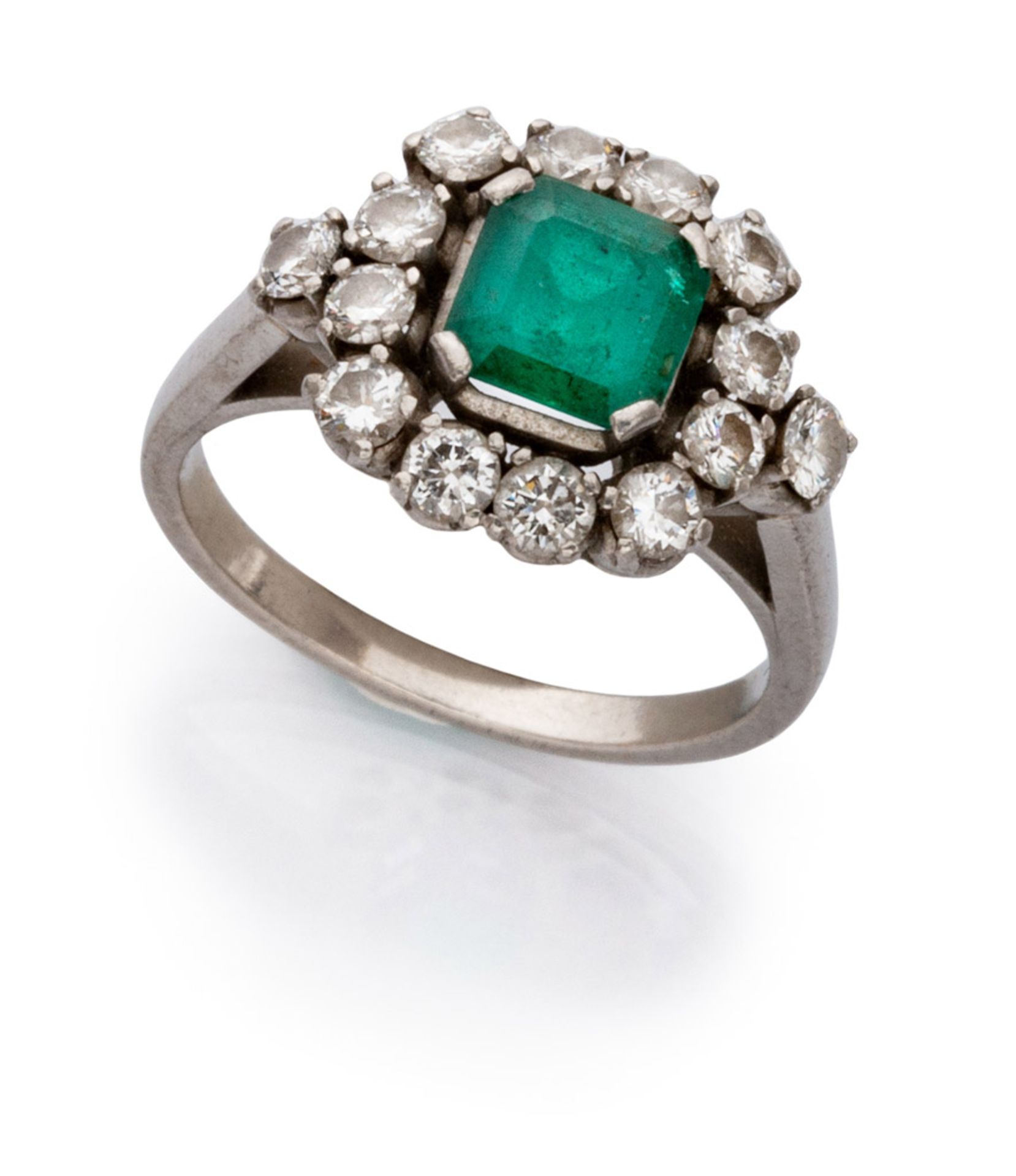 RING in white gold 18 kts., with central emerald edged by diamonds. Emerald ct. 1.30 ca, diamonds