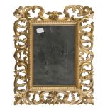 SMALL GILTWOOD MIRROR, FLORENCE 19TH CENTURY with frame carved to scrolls of leaves. Measures cm. 40