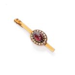 ATTRACTIVE BROOCH in yellow gold 18 kts., with pomegranate cabochon surrounded by small pearls.