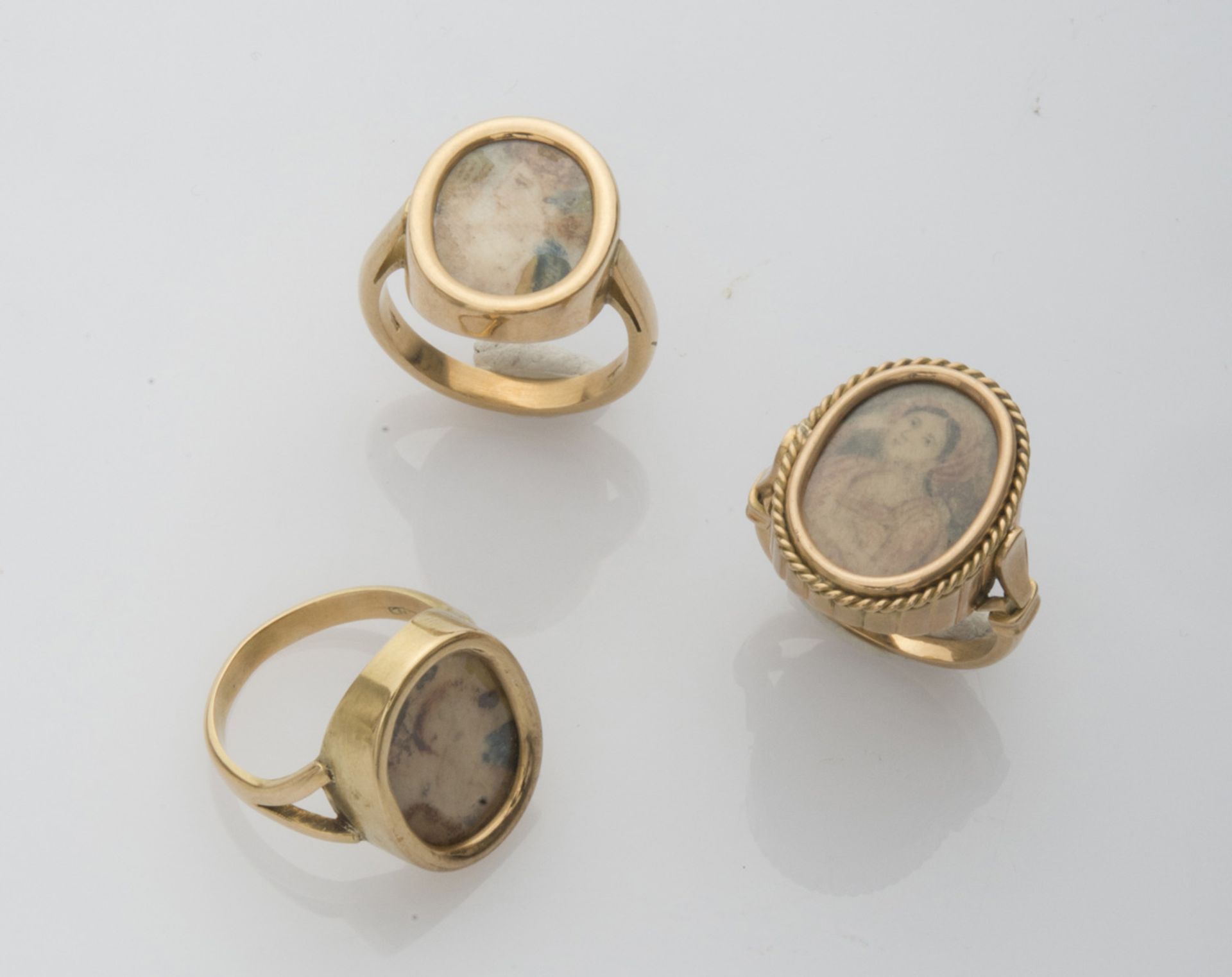 THREE RINGS with mount in yellow gold 18 kts., with miniatures representing female figures. Total