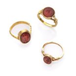THREE ATTRACTIVE RINGS with mount in yellow gold 18 kts., and antique engraved carnelians with