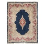 SPLENDID KIRMAN CARPET, MID- 20TH CENTURY medallion with flower branches on red ground in a blue