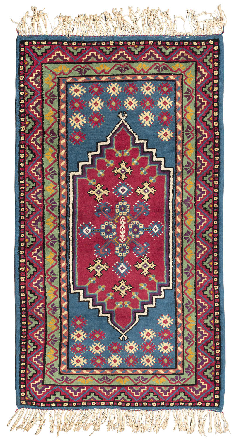 NORTHAFRICAN CARPET, MID-20TH CENTURY with lozenge medallion, in the field on light blue ground.