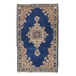 KIRMAN CARPET, MID-20TH CENTURY arabesque medallion with flowers, in the center field on blue