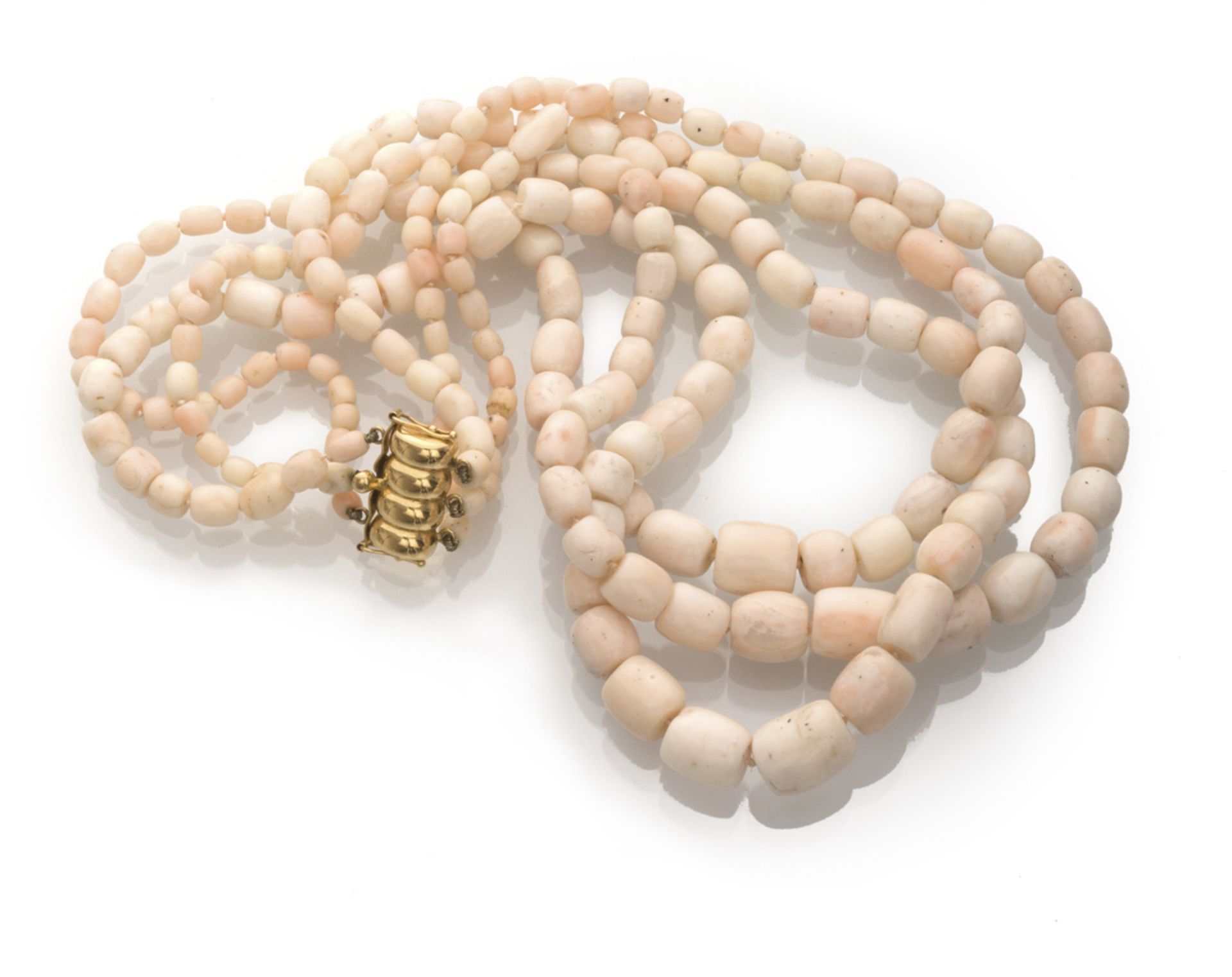 ATTRACTIVE NECKLACE three threads of white coral in pink tones consisting of scaled elements.