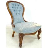 A Victorian nursing chair, with spoon shaped button back upholstered in blue sprig fabric,