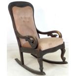A late Victorian / Edwardian stained mahogany rocking chair with pink velvet seat and back,