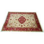 A modern Keshan rug with beige ground, central red medallion and wide red border, 280 by 200cm.