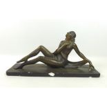 An Art Deco plaster sculpture, modelled as a reclining female nude with golden finish,