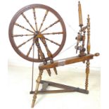 A 19th century fruitwood spinning wheel, 100 by 65 by 115cm high.