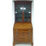 A George III mahogany bureau bookcase, twin astragal glazed doors enclosing three shelves,