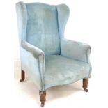 A Victorian wing back armchair, upholstered in pale blue velvet,