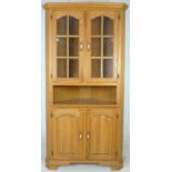 A modern American oak corner cabinet, with glazed upper section, 100 by 62 by 200cm high.