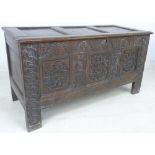 A 17th century oak coffer, the three panels carved with guilloche scroll roundels,