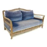 An Edwardian mahogany bergere three seater settee, with carved decoration to front,