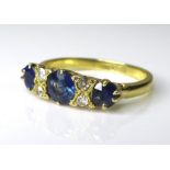 An 18ct yellow gold sapphire and diamond ring, the central stone approximately 0.6ct, flanked by